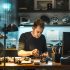a professional locksmith in a sleek sydney office, surrounded by high-tech tools and a modern workstation, expertly examines a complex lock mechanism under bright, focused lighting.